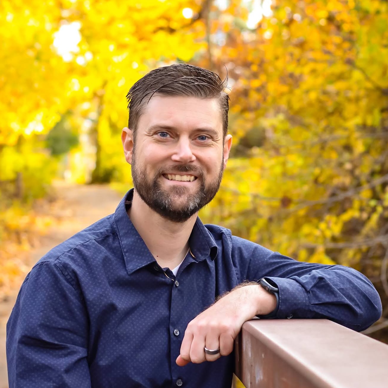 Image of Joel Holmes with fall leaves in the background.